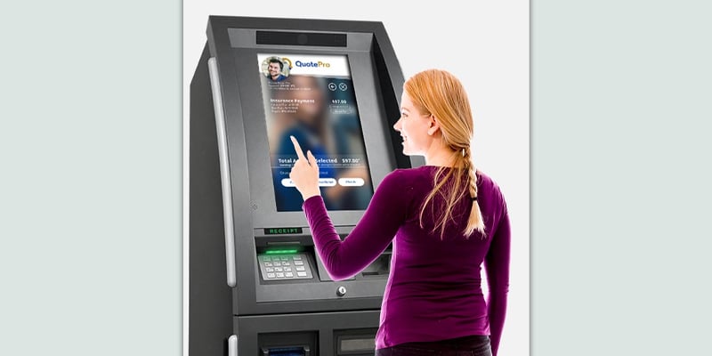 A woman touching the screen of an ATM.