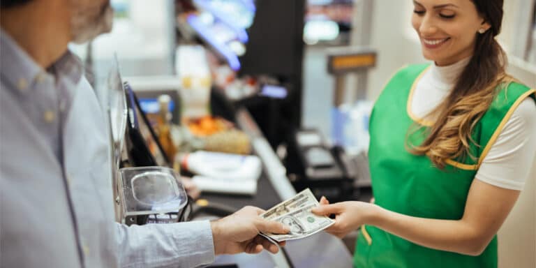 Customer exchanging cash with an employee at a store